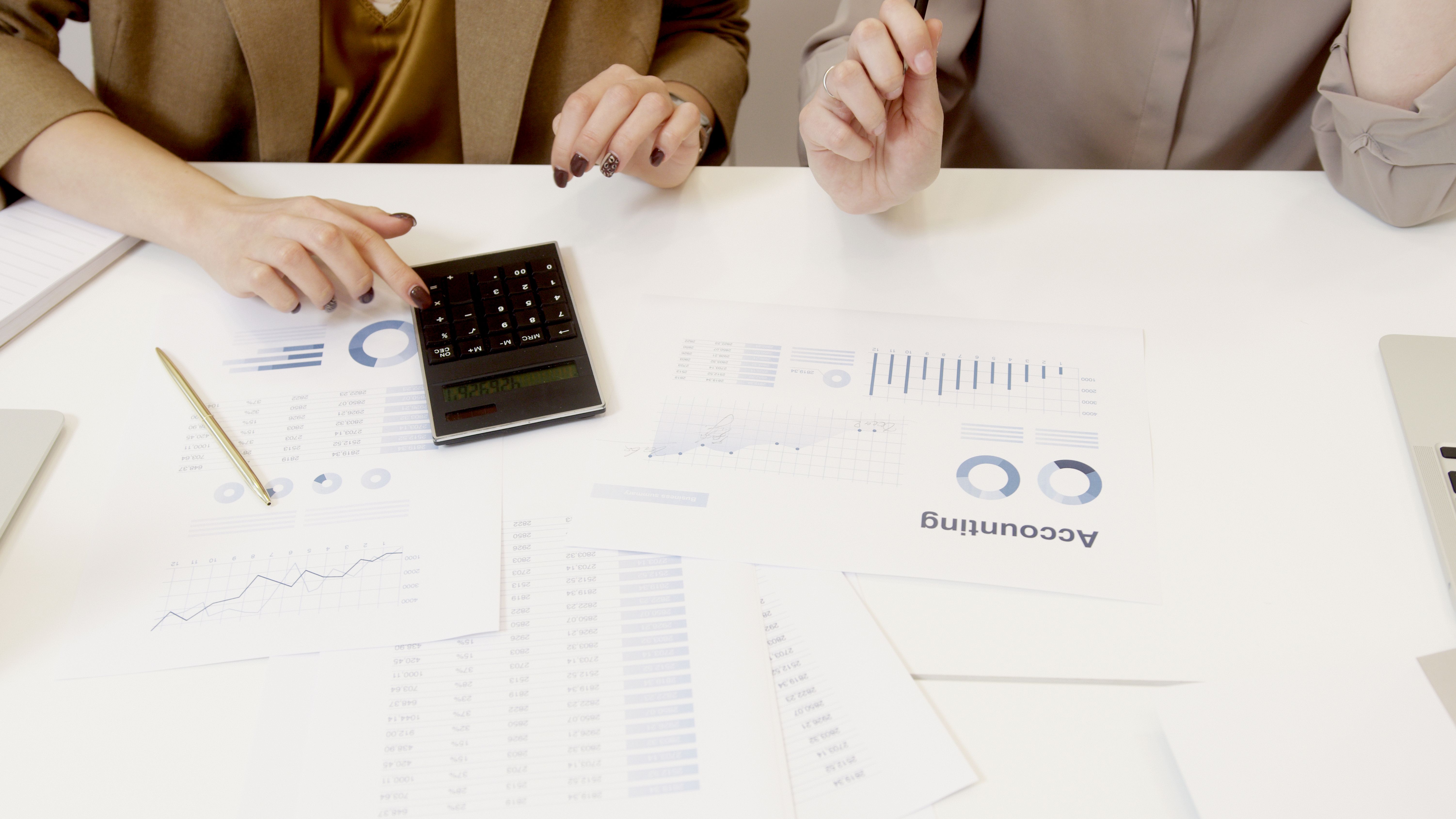 Two professionals analyzing financial documents with a calculator during a law firm audit review